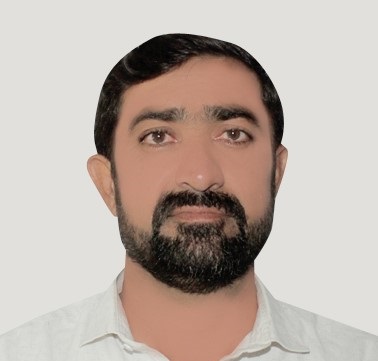 A man with short black hair, a trimmed black beard and mustache, wearing a white collared shirt, facing forward against a plain light gray background.